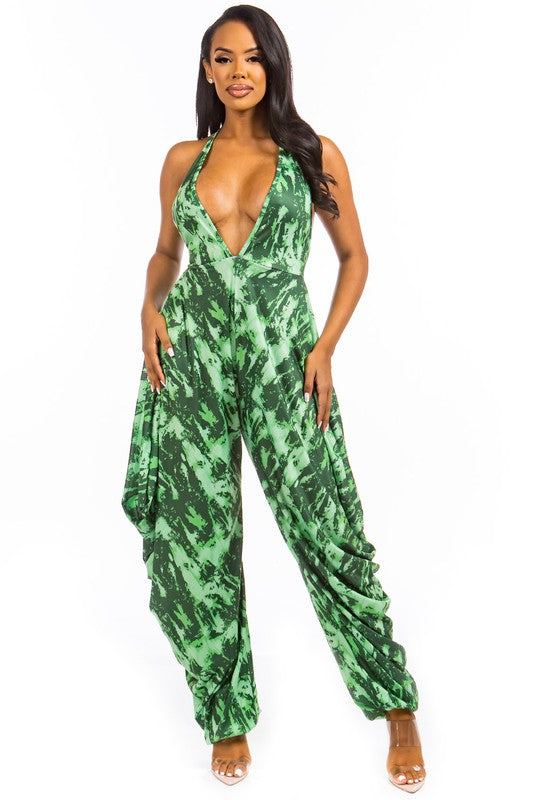 Make a bold statement in this sexy tie-dye jumpsuit featuring a plunging deep V-neckline and striking open back with a delicate back strip. The sleeveless design and elasticized waist create a flattering silhouette that hugs your curves, while the relaxed hem-style pants add effortless movement and style.

Crafted from a soft, stretchy blend of polyester and spandex, this jumpsuit offers both comfort and eye-catching appeal — perfect for nights out or special occasions.

Fit: Bust 34", Waist 22" (elasticize